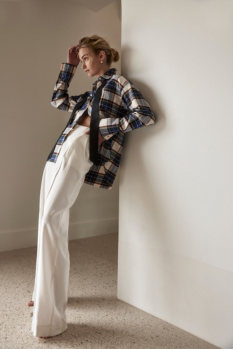 A model wearing the Rilke Brushed Twill Tuxedo Shirt in royal blue, cream, red and yellow plaid.